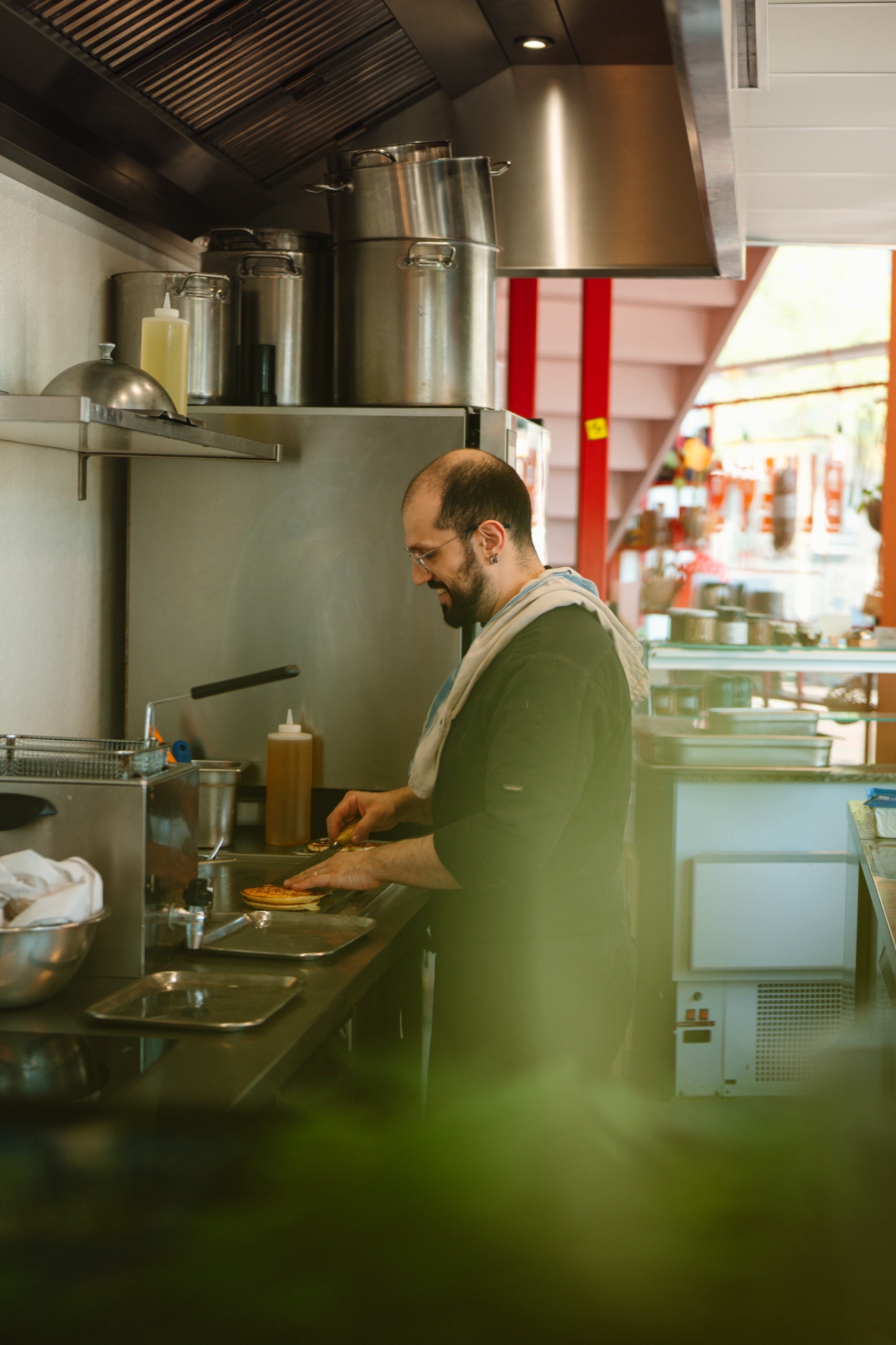 Person cooking in a kitchen with stainless steel appliances and various kitchen items.